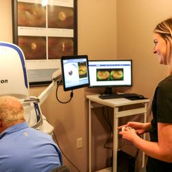 Family Vision Clinic - Man having photos taken with Family Vision Clinic OPTOS machine