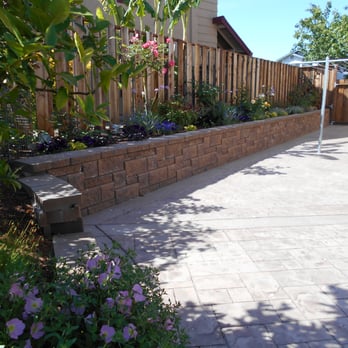Sanchez - Side yard AFTER (with retaining wall, patio, new fence and gate, new clothesline, and 50' flower bed). - Gardeners Near Me Sanchez - Side yard AFTER (with retaining wall, patio, new fence and gate, new clothesline, and 50' flower bed). - Gardeners Near Me