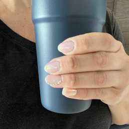 Gel manicure with iridescent chrome on four nails and sparkly stones on one nail.