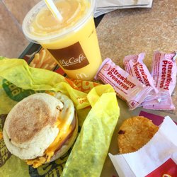 McDonald's - Delicious egg mcmuffin meal with an orange juice and strawberry preserves