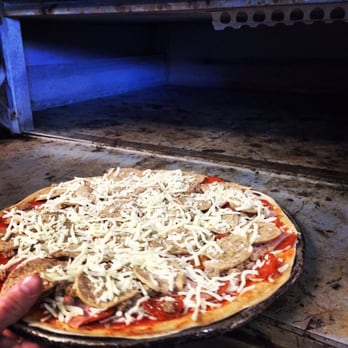 Panzera's Pizza - a person taking a pizza out of the oven - Pizza Near Me - Columbus, Ohio Panzera's Pizza - a person taking a pizza out of the oven - Pizza Near Me - Columbus, Ohio