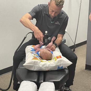 New Hope Family Wellness - Dr. Kevin adjusting a 4 week old baby that has cholic. - Chiropractors Near Me - Aurora, Colorado New Hope Family Wellness - Dr. Kevin adjusting a 4 week old baby that has cholic. - Chiropractors Near Me - Aurora, Colorado