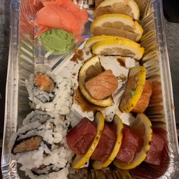 a tray of sushi and vegetables