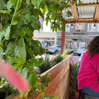 Understory - a woman sitting at a table on a balcony - Filipino Near Me - Oakland, California Understory - a woman sitting at a table on a balcony - Filipino Near Me - Oakland, California