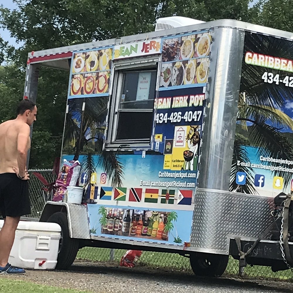 Caribbean Jerk Pot - a man standing next to a food truck - Food Trucks Near Me - Lynchburg, Virginia