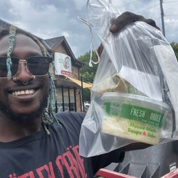 Me holding a bag containing the salmon Panini outside of the John Creek location