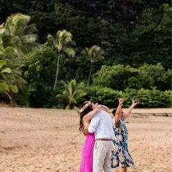 Kauai Elopements - One of my fav pics is of our officiant Primrose going "woo hoo!" In the background as we kiss. Captured by the talented Rachel Crane.
