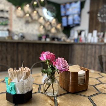 The Little Coffee Shoppe - a table with a vase of flowers - Coffee & Tea Near Me - Pompano Beach, Florida