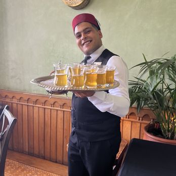 MS Travel & Tours - Hospitable server with a tray of Moroccan tea. - Travel Services Near Me - Burbank, California