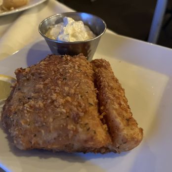 The Fat Radish - Whitefish (deep fried) - A fried fish fillet served with a lemon wedge and a small cup of tartar sauce on a white plate, likely at a restaurant. - Breakfast & Brunch Near Me - Cornucopia, Wisconsin