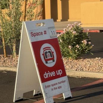 Target - A portable sign on a sidewalk displays instructions for drive-up service, including entering a space number in an app. - Department Stores Near Me - Mesa, Arizona