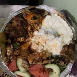 Shish kebab over rice with white and hot sauce Shish kebab over rice with white and hot sauce