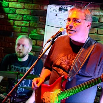 Hilltop Tavern - a man playing a guitar and singing into a microphone - Dive Bars Near Me - Lodi, New Jersey