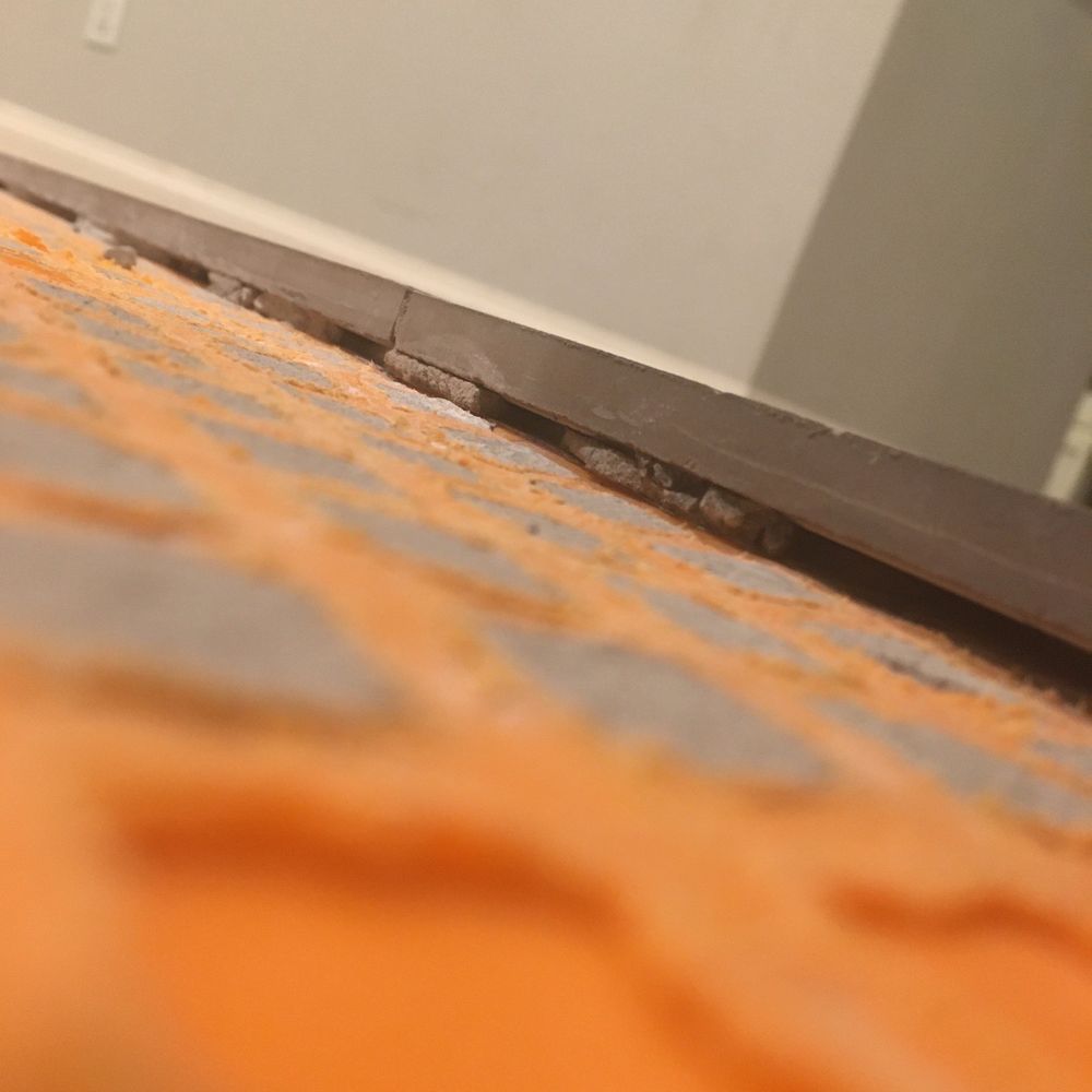 Cen-Tex Tile & Floor Center - Gaps in thin-set in exposed tiles next to tiles removed due to lippage or had that had already popped up. - Flooring Near Me - Temple, Texas