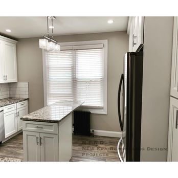 NERD Projects - a kitchen with white cabinets and black appliances - Interior Design Near Me