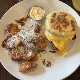 English Muffin Sandwich. Cheesy eggs and bacon with a side of potatoes. English Muffin Sandwich. Cheesy eggs and bacon with a side of potatoes.