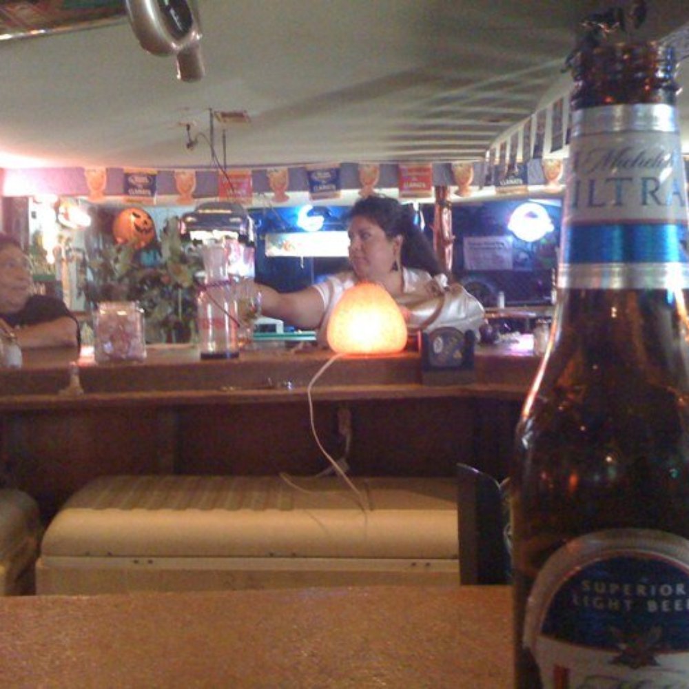 The Hideout - a woman sitting at a bar with a bottle of beer - Nightlife Near Me - Canyon Lake, Texas The Hideout - a woman sitting at a bar with a bottle of beer - Nightlife Near Me - Canyon Lake, Texas