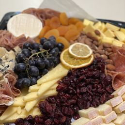a platter of cheese, fruit, and meats a platter of cheese, fruit, and meats