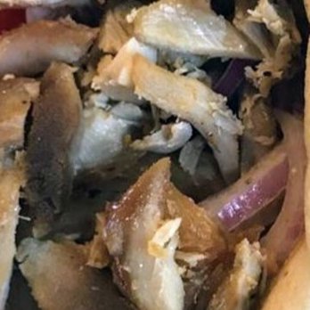GRK Grill - Chicken Gyro. Bits and pieces of overcooked decrepit rubberized looking meat. Inedible. SAD! - A detailed close-up of chicken meat pieces, showing a mix of cooked and overcooked, rubbery-looking portions, with some bones and skin visible. - Greek Near Me - Fairfield, Connecticut