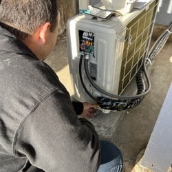 Building Efficiency - Building Efficiency Team Installing a heat pump condesner.