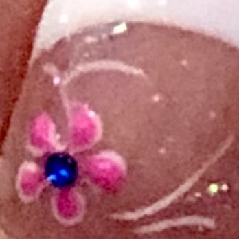 VS Nail Bar - Kayla did this perfect little flower to my French Pedi. Happy Spring! - A fingernail features a pink flower design with a blue gem at the center, decorated with white accents and lines. - Nail Salons Near Me - Phoenix, Arizona