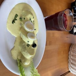 Boiled potatoes in sauce called - Papa a La Huancaina with a Peruvian juice called chicha morada made from purple corn.