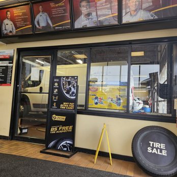 Midas - Inside a Midas auto repair shop, promotional posters for tire services and maintenance are visible, along with a tire sale sign and a service counter. - Auto Repair Near Me - Markham, Ontario