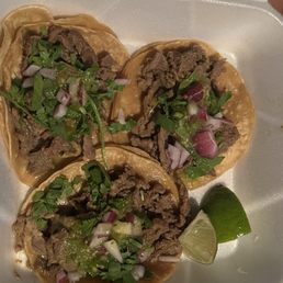 Three asada tacos with cilantro, onions, and green chile/salsa. Three asada tacos with cilantro, onions, and green chile/salsa.