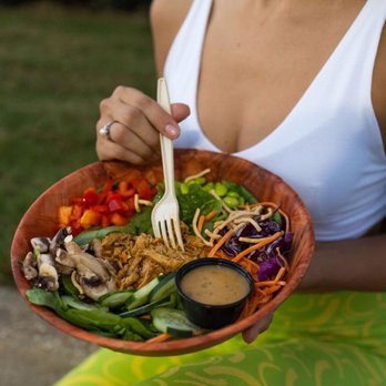 Salad Station - a woman holding a bowl of salad - Salad Near Me - Gulfport, Mississippi Salad Station - a woman holding a bowl of salad - Salad Near Me - Gulfport, Mississippi