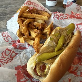 Devil Dawgs - Maxwell St. Polish French Fries - A hot dog with pickles, onions, and ketchup in a bun, accompanied by a serving of French fries on a paper tray. - Hot Dogs Near Me - Chicago, Illinois