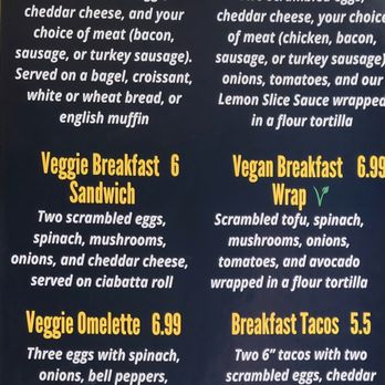 Lemon Slice Cafe - Menu board at Lemon Slice Cafe in Silver Spring, MD, featuring breakfast options including sandwiches, wraps, veggie dishes, omelette, and tacos. Descriptions include ingredients like scrambled eggs, cheddar cheese, meats, vegetables, and sauces. Prices range from $5.50 to $6.99, with additional options for avocado, home fries, and meat. The menu emphasizes vegetarian and vegan choices, with a focus on breakfast and brunch items. - Desserts Near Me - Silver Spring, Maryland