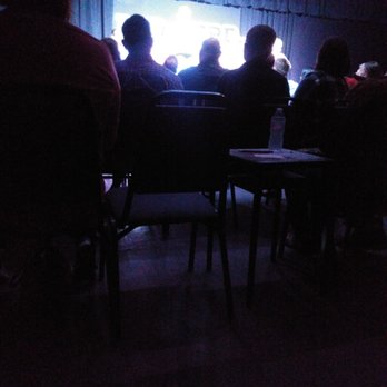 Red Curb Improv Comedy - a group of people sitting in a dark room - Comedy Clubs Near Me - Avon, Indiana