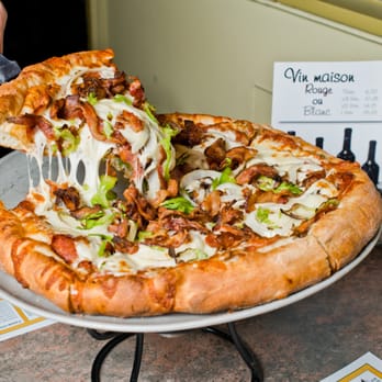 Pizza Giffard - a person cutting into a pizza - Pizza Near Me - Quebec City, Quebec Pizza Giffard - a person cutting into a pizza - Pizza Near Me - Quebec City, Quebec