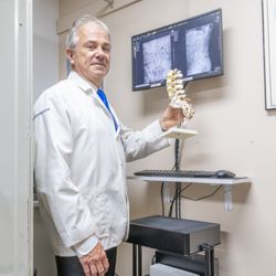 Skocik Chiropractic - Dr Skocik comparing a spine model to his x-rays.