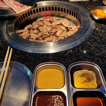 Iron Age Glenview - Brisket on the grill with pork belly waiting to be cooked. The house sauce (bottom right) was excellent! - Barbeque Near Me - Glenview, Illinois Iron Age Glenview - Brisket on the grill with pork belly waiting to be cooked. The house sauce (bottom right) was excellent! - Barbeque Near Me - Glenview, Illinois