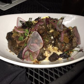 Lucille's - Grits and Oxtails dressed with mixed vegetables. - New American Near Me - Houston, Texas