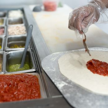 Good Wood Pizzeria - a person making a pizza - Pizza Near Me - Lincolnton, North Carolina Good Wood Pizzeria - a person making a pizza - Pizza Near Me - Lincolnton, North Carolina