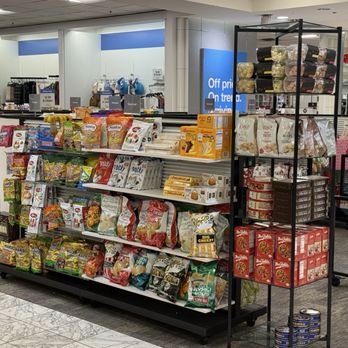 Macy's - Shelves stocked with various snack foods, including chips, cookies, and canned goods, inside a retail store environment. - Department Stores Near Me - Albuquerque, New Mexico