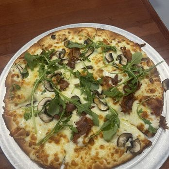 Bruno’s Pizzeria - The Field and Fork   White sauce, mushrooms, prosciutto truffle oil, Parmesan cheese, and topped with fresh arugula after baking. - Pizza Near Me - Batesville, Arkansas
