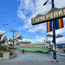 Twin Peaks Tavern - Twin Peaks sign shown with rainbow flag, Jane Warner Plaza, & vintage MUNI F Market trolley