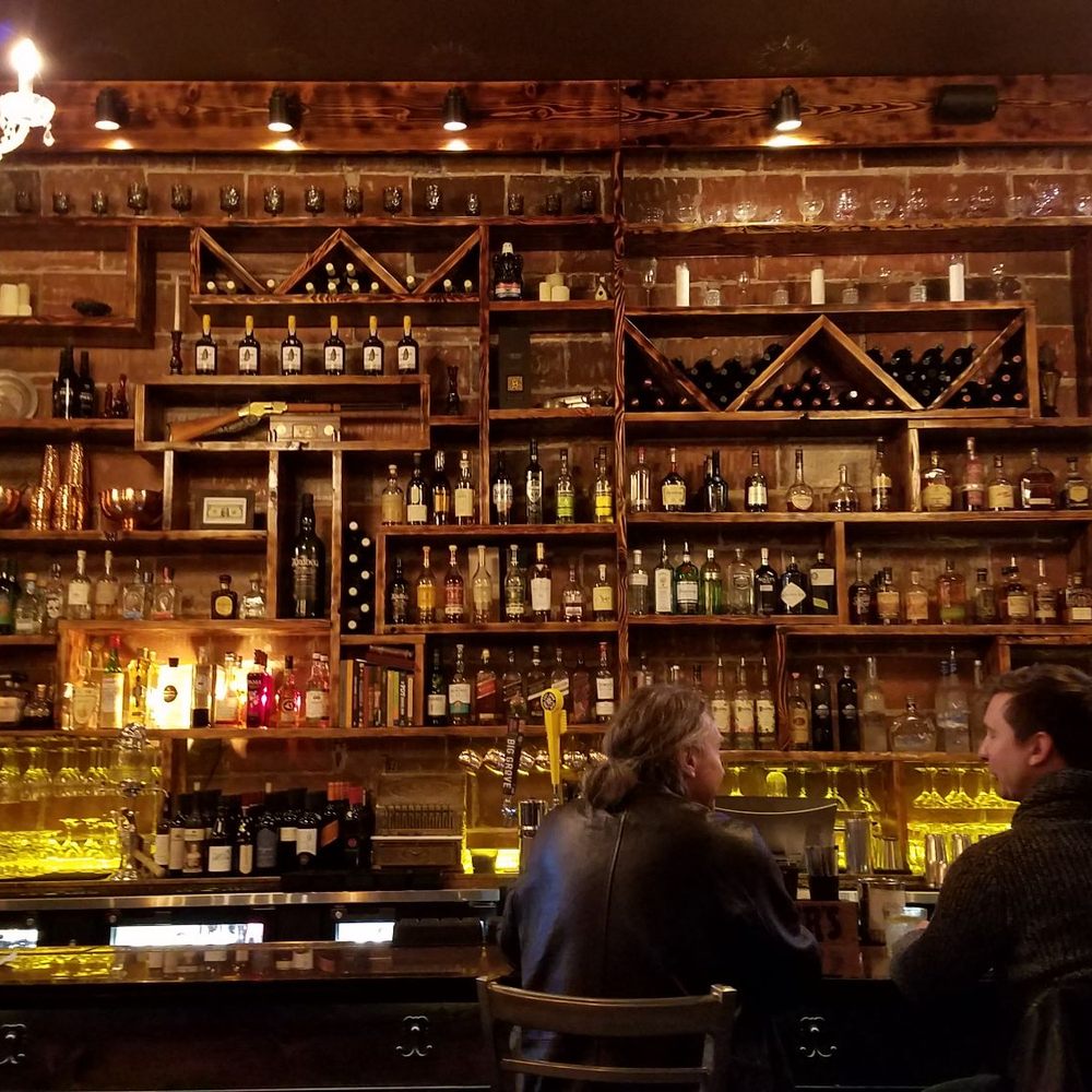 two people sitting at a bar two people sitting at a bar