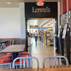Arby’s - Tables and entrance to the market next door , a convenient store