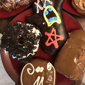 Voodoo Doughnut - All vegan - clockwise from left: Dirt, Voodoo Doll, Maple Bar, Maple Cream - Donuts Near Me - Denver, Colorado Voodoo Doughnut - All vegan - clockwise from left: Dirt, Voodoo Doll, Maple Bar, Maple Cream - Donuts Near Me - Denver, Colorado