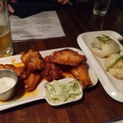 Present Company Public House - On the left are the Nashville Hot Chicken Wings with Dill Ranch dipping sauce and Shaved Celery. On the right are the Steamed Bao Buns.
