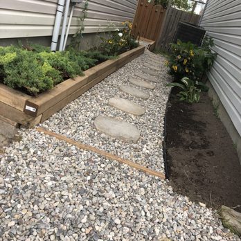 Ottawa Renovation & Construction - Flagstone and river-washed stone pathway with wooden border wall. - General Contractors Near Me - Nepean, Ontario Ottawa Renovation & Construction - Flagstone and river-washed stone pathway with wooden border wall. - General Contractors Near Me - Nepean, Ontario