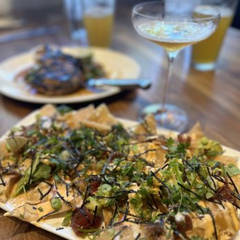 Yard House - Poke Nachos (foreground) Thai Grilled Pork Chop (background) - New American Near Me - Irvine, California Yard House - Poke Nachos (foreground) Thai Grilled Pork Chop (background) - New American Near Me - Irvine, California