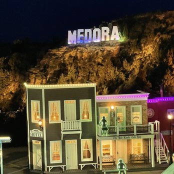 Medora Musical - a view of a building with a neon sign above it - Restaurants Near Me