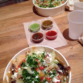 District Taco - Carne asada nachos in front and Barbacoa bowl back with plenty of fresh salsa to choose from. - Mexican Near Me - Washington, DC, District of Columbia