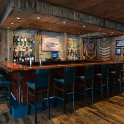 Topside Grille - The Hacker-Craft Bar at the TOPSIDE GRILLE is made of genuine Hacker mahogany, stone accents and hand-stictched leather chairs.