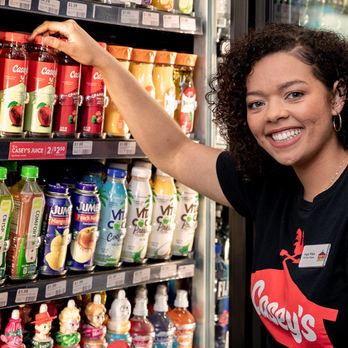Casey's - a woman standing in front of a vending machine - Pizza Near Me - Edmond, Oklahoma
